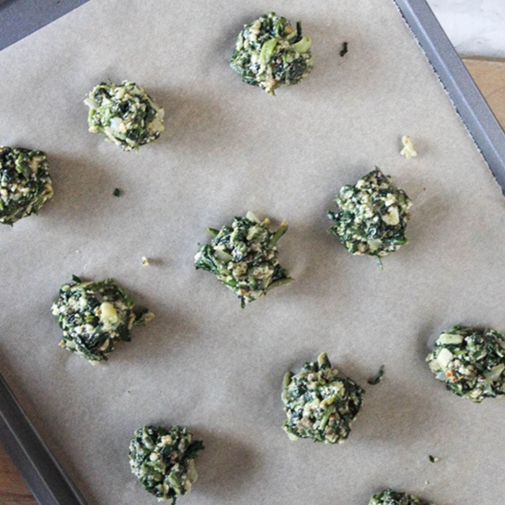 last process for spinach balls, rolled and on a parchment lined baking sheet