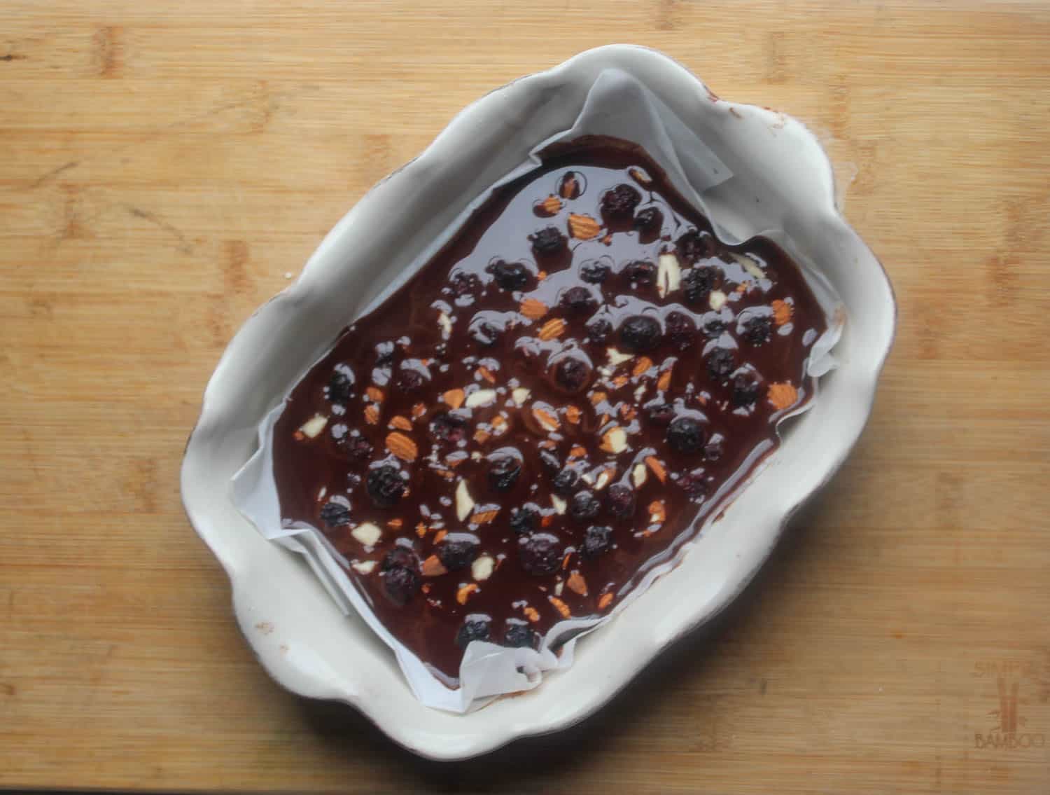 a picture of chocolate in pan with almonds and cranberries added