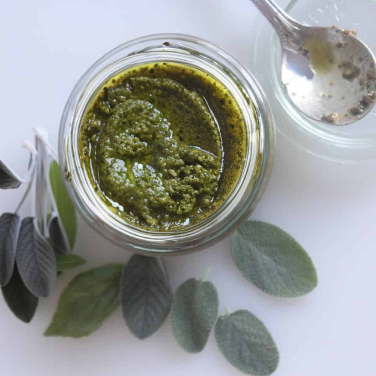 an overhead photo of sage pesto sauce in a jar