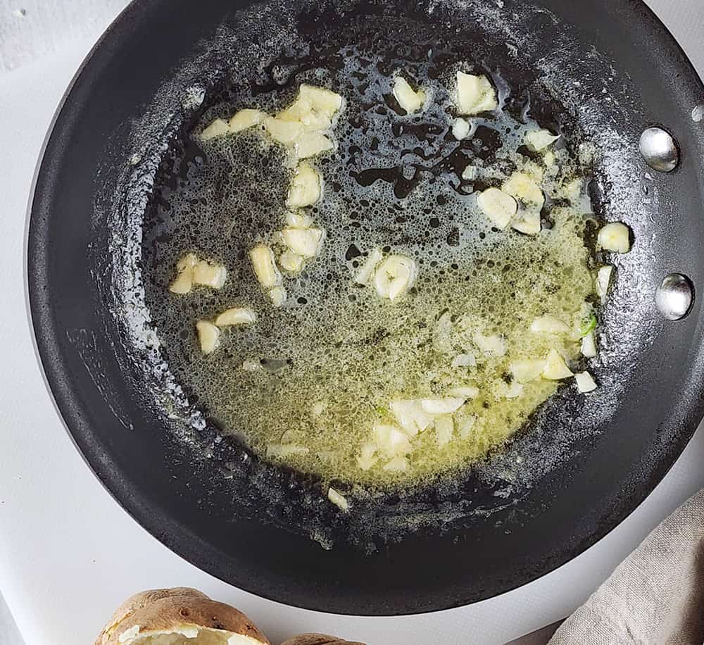 A picture of butter and garlic cooking in a pan