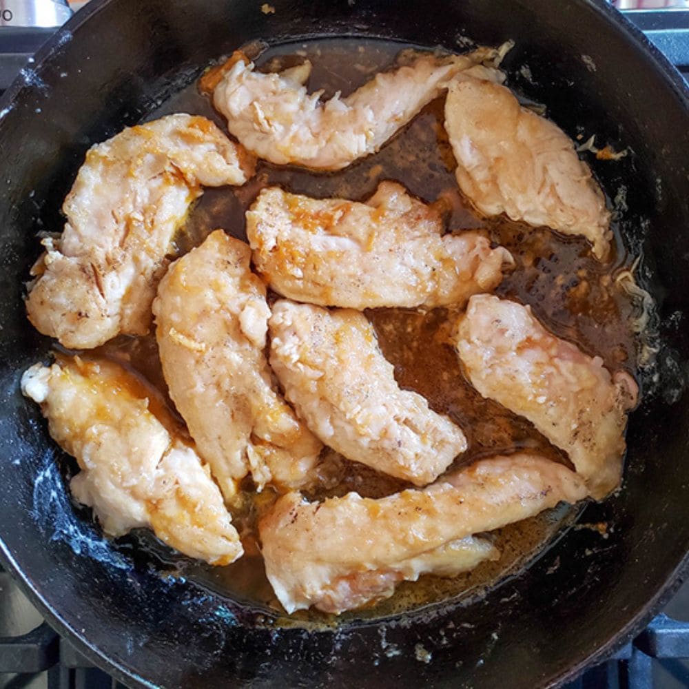 process step 4 chicken tenders cooking in sauce in a skilet