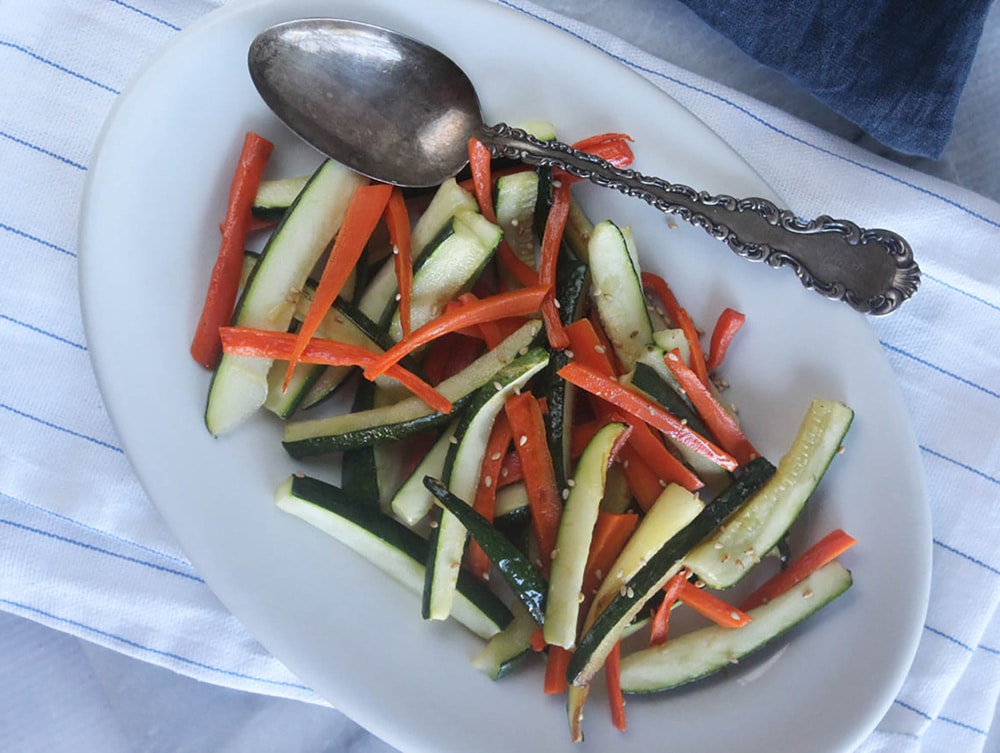 An overhead view of zucchini and carrots on a plate