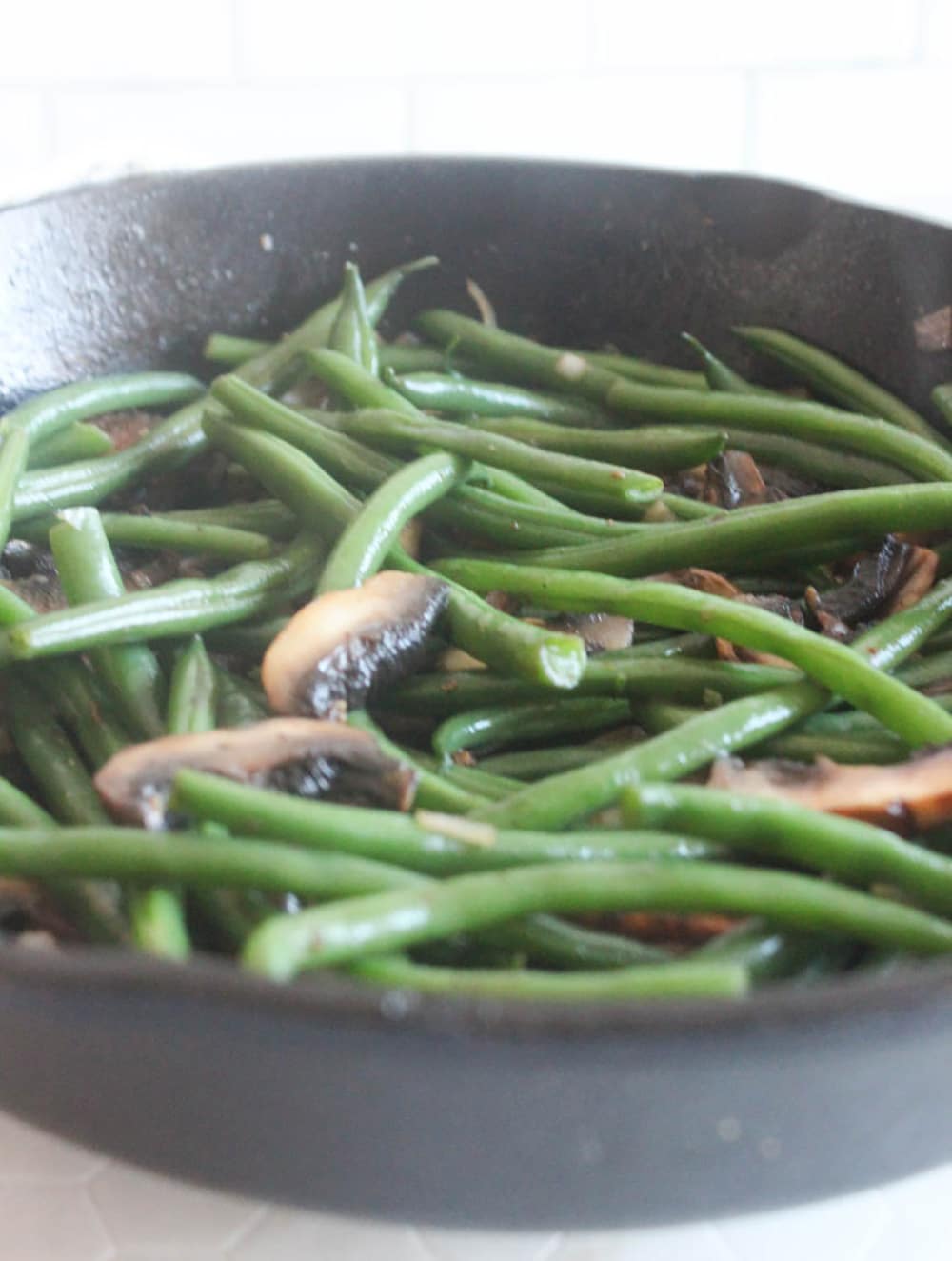 A picture of green beans and mushrooms in a skillet 