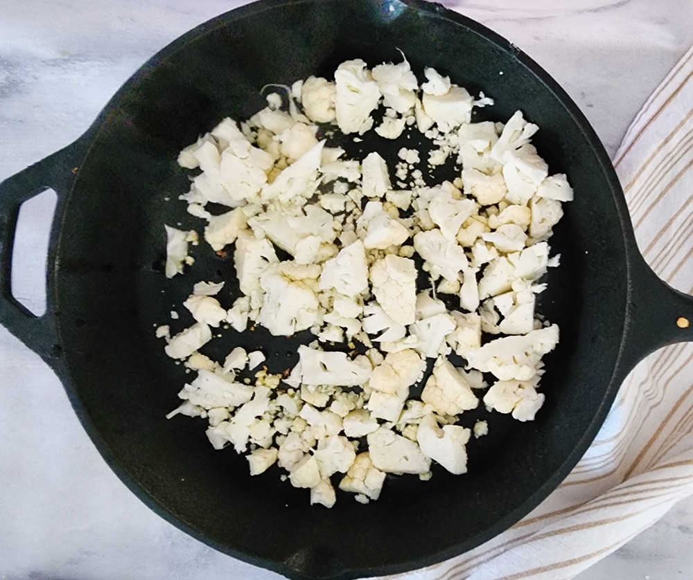 a picture of raw cauliflower in a skillet 