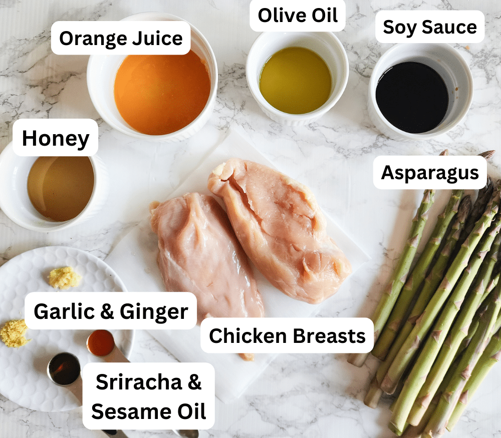 A picture of the ingredients needed to make this recipe: honey, orange juice, soy sauce, asparagus, chicken breasts garlic, ginger, sriracha sauce, sesame oil