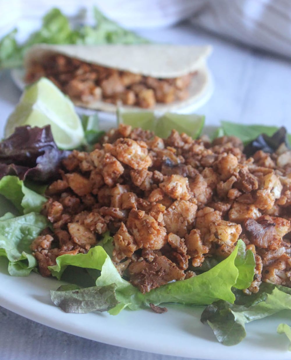 A picture of vegetarian taco meat on a platter with a taco in the background