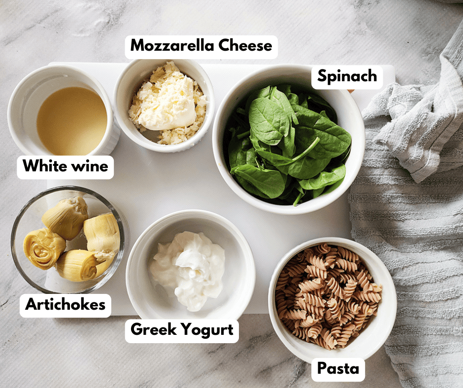 a picture of spinach artichoke pasta ingredients on a white tray
