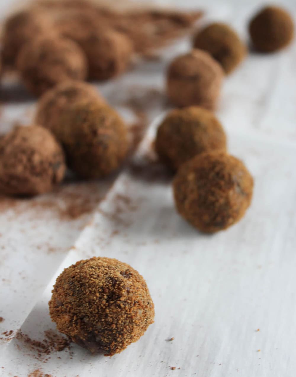 A picture of sugar plums rolled in sugar on parchment paper