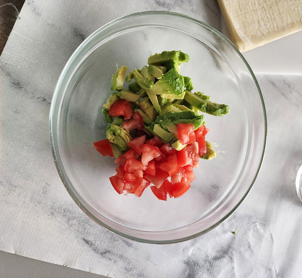 Avocado egg rolls Process step1: tomatoes, onion, avocado in a glass bowl