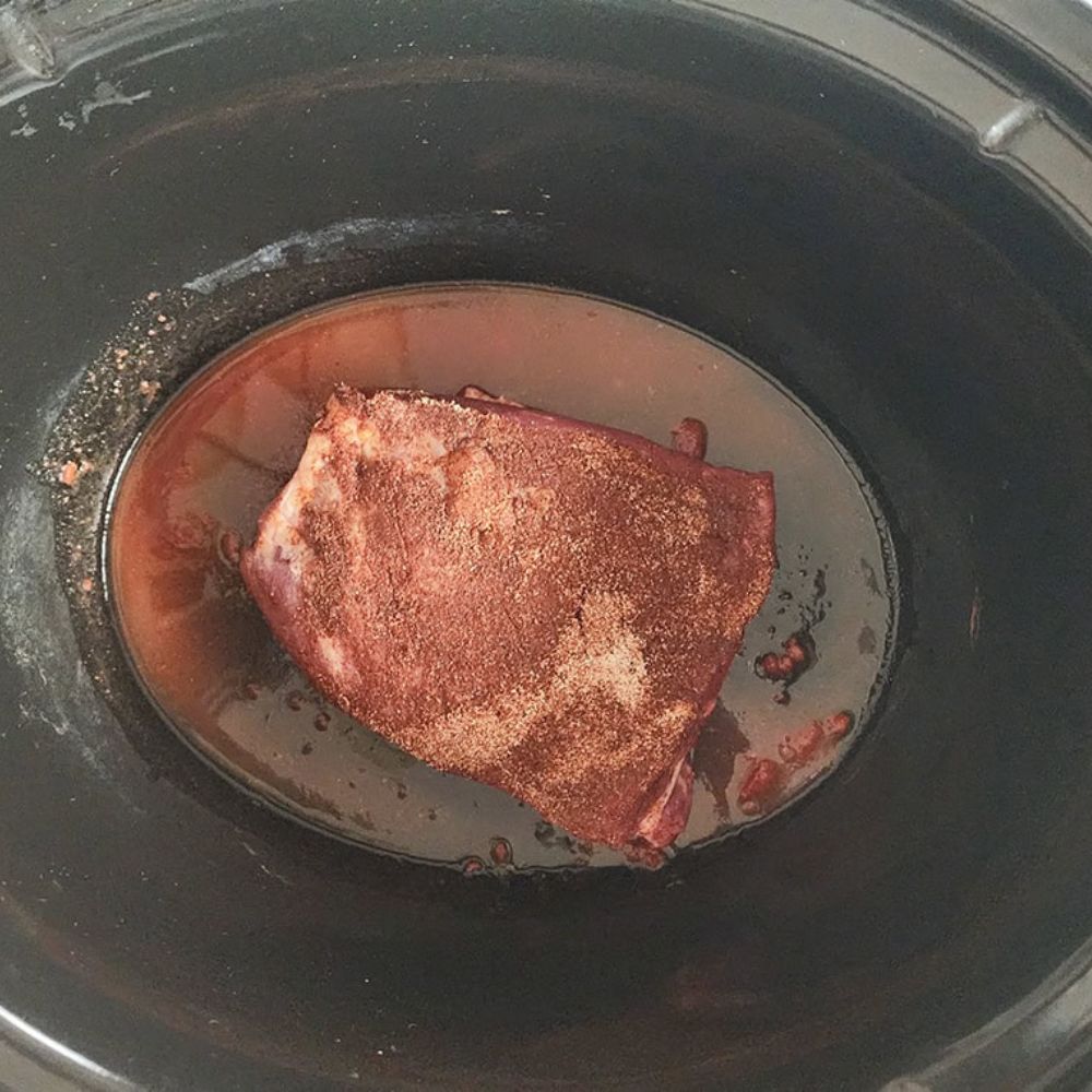 a picture of tri tip seasoned in a slow cooker not cooked yet