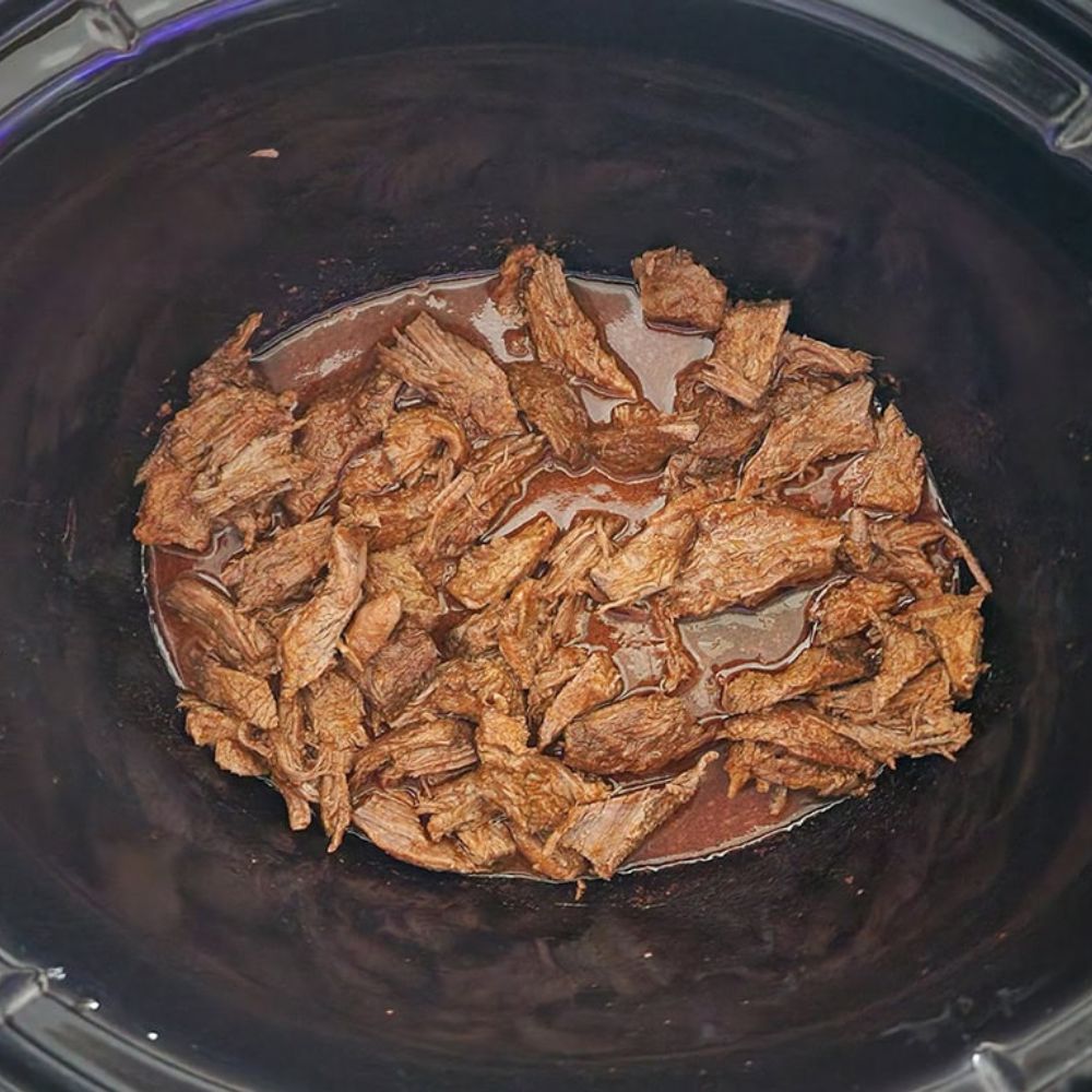 a picture of shredded tri tip in a crockpot