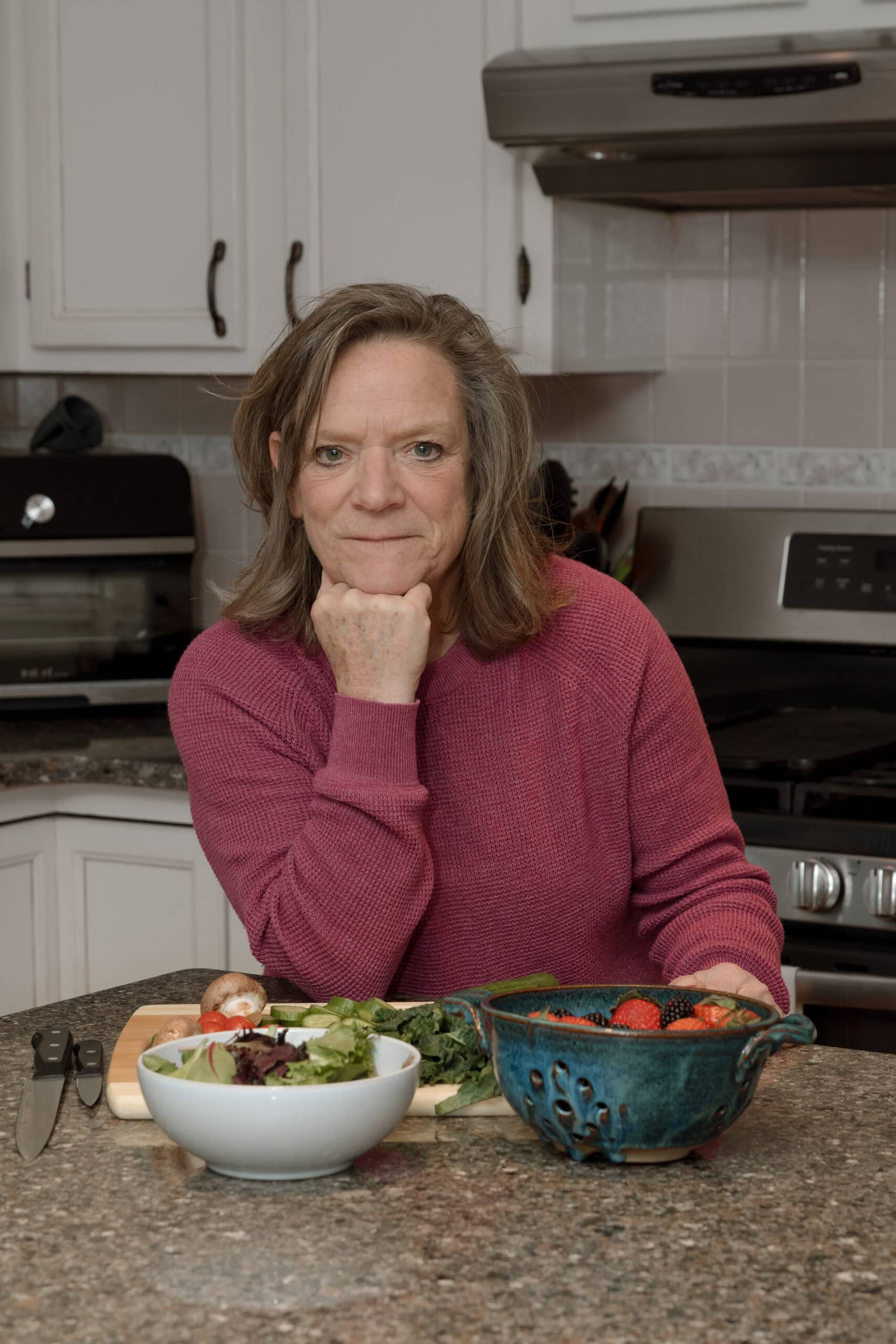 a picture of anne lawton,  the author of simple and saovry standing in her kitchen