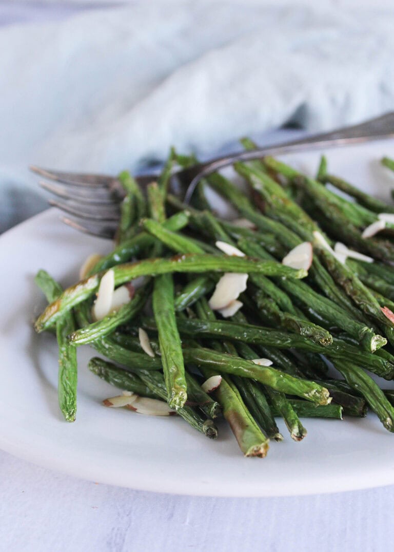 air fryer green beans with almonds on a white plate