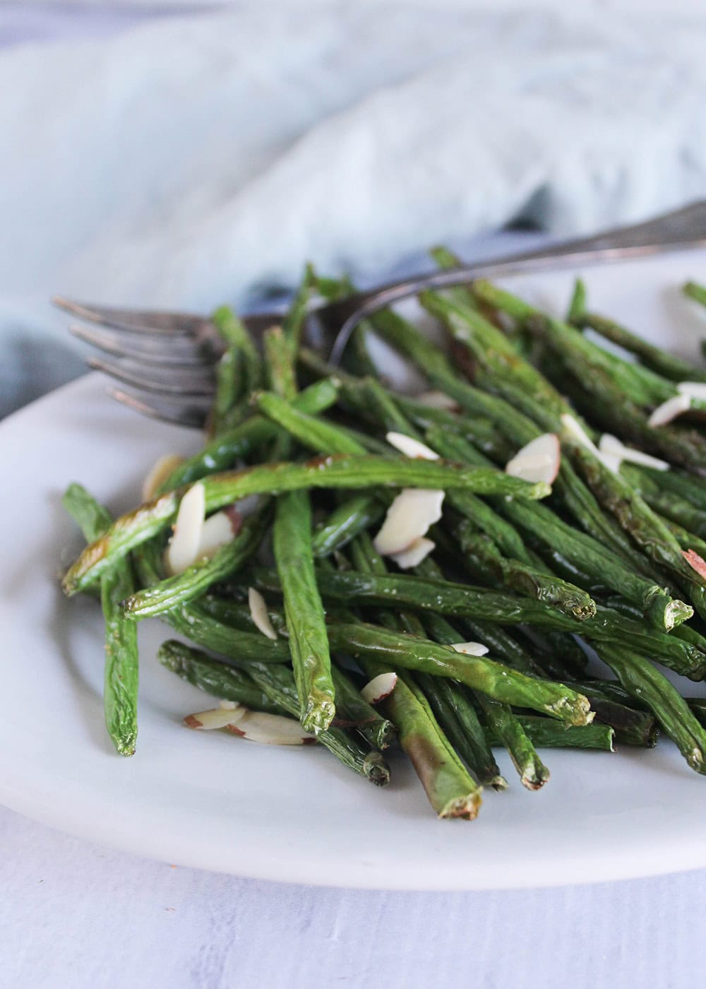air fryer green beans with almonds on a white plate 