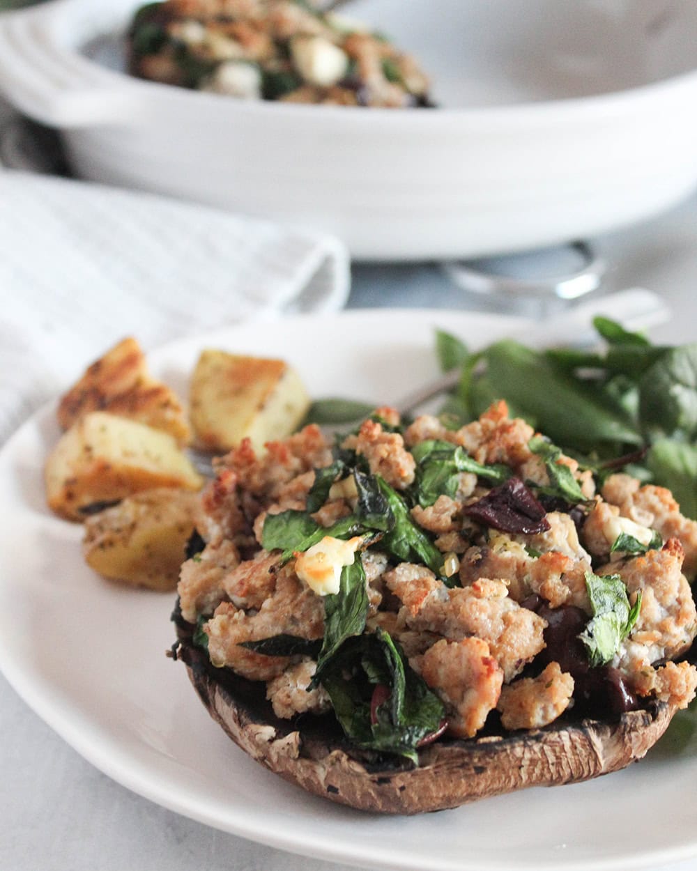 Image 3 (Finished Mushroom Close-Up): Close-up of a baked portobello mushroom stuffed with ground turkey, spinach, olives, and melty cheese, highlighting its golden, crisped top.