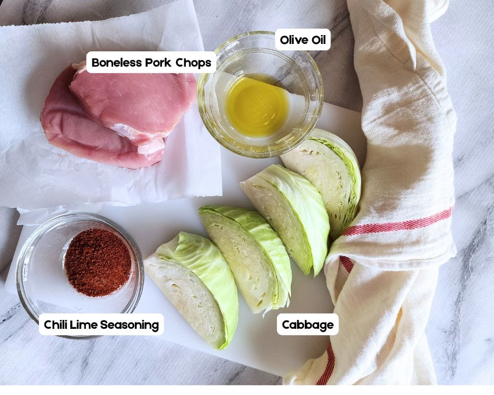 a view of the ingredients needed to make chili lime pork chops : cabbage wedges, chili lime seasoning, olive oil, pork chops