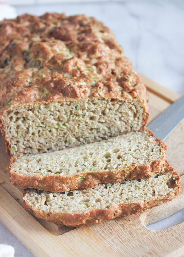 a loaf of zucchini bread on a cutting board with slices