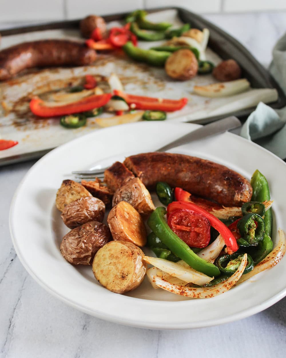 sheet pan sausage and peppers served in a bowl 