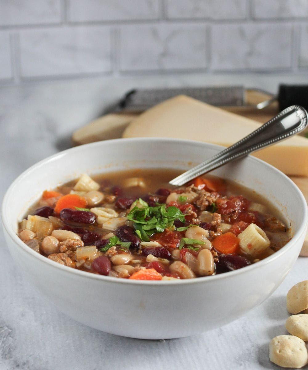 a picture of pasta fagioli soup in white bowl with a spoon