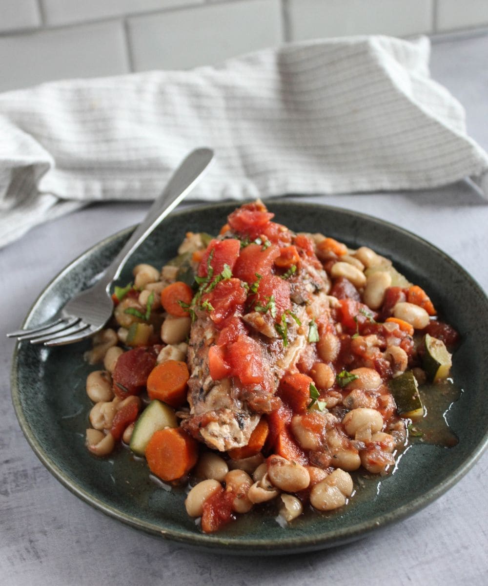 a picture of Tuscan chicken plated on a blue plate with a fork