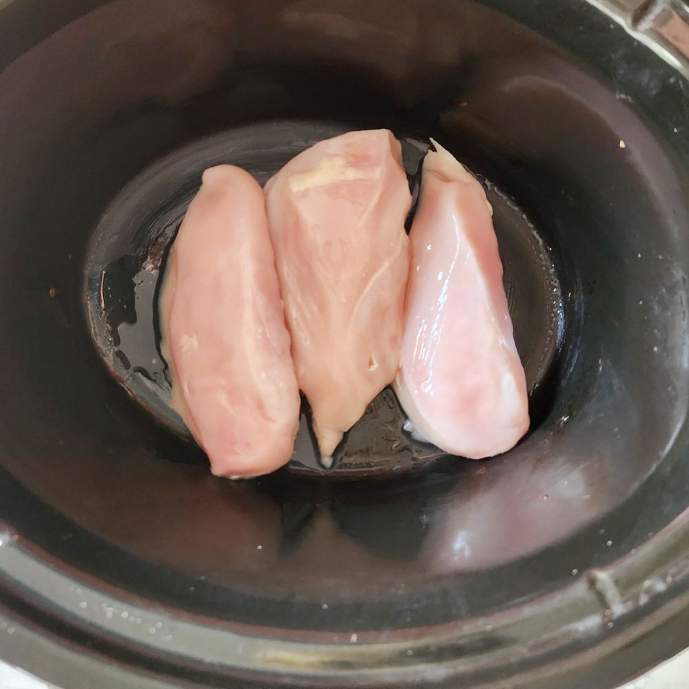 process step 1, 3 uncooked boneless chicken breasts in a slow cooker