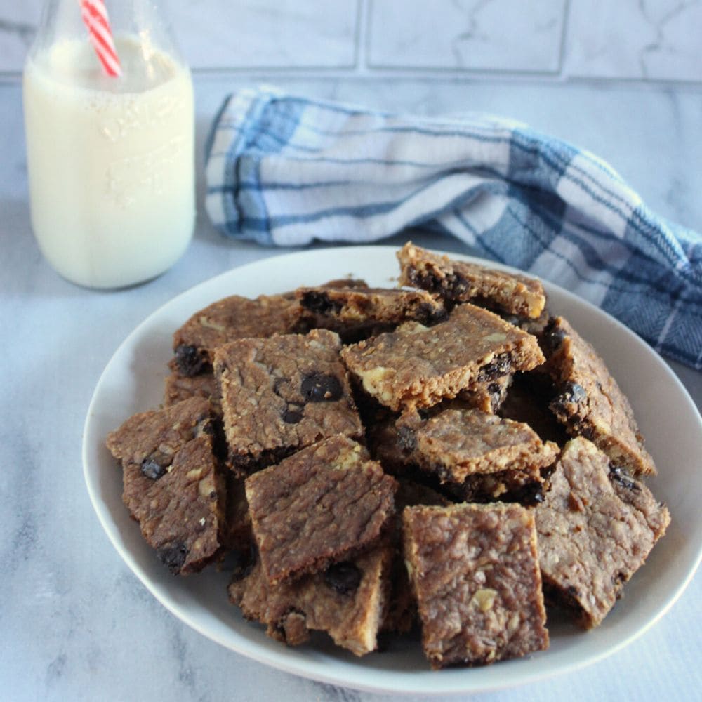 chocolate chip cookie brittle on a white plate with milk in bottle in the background 