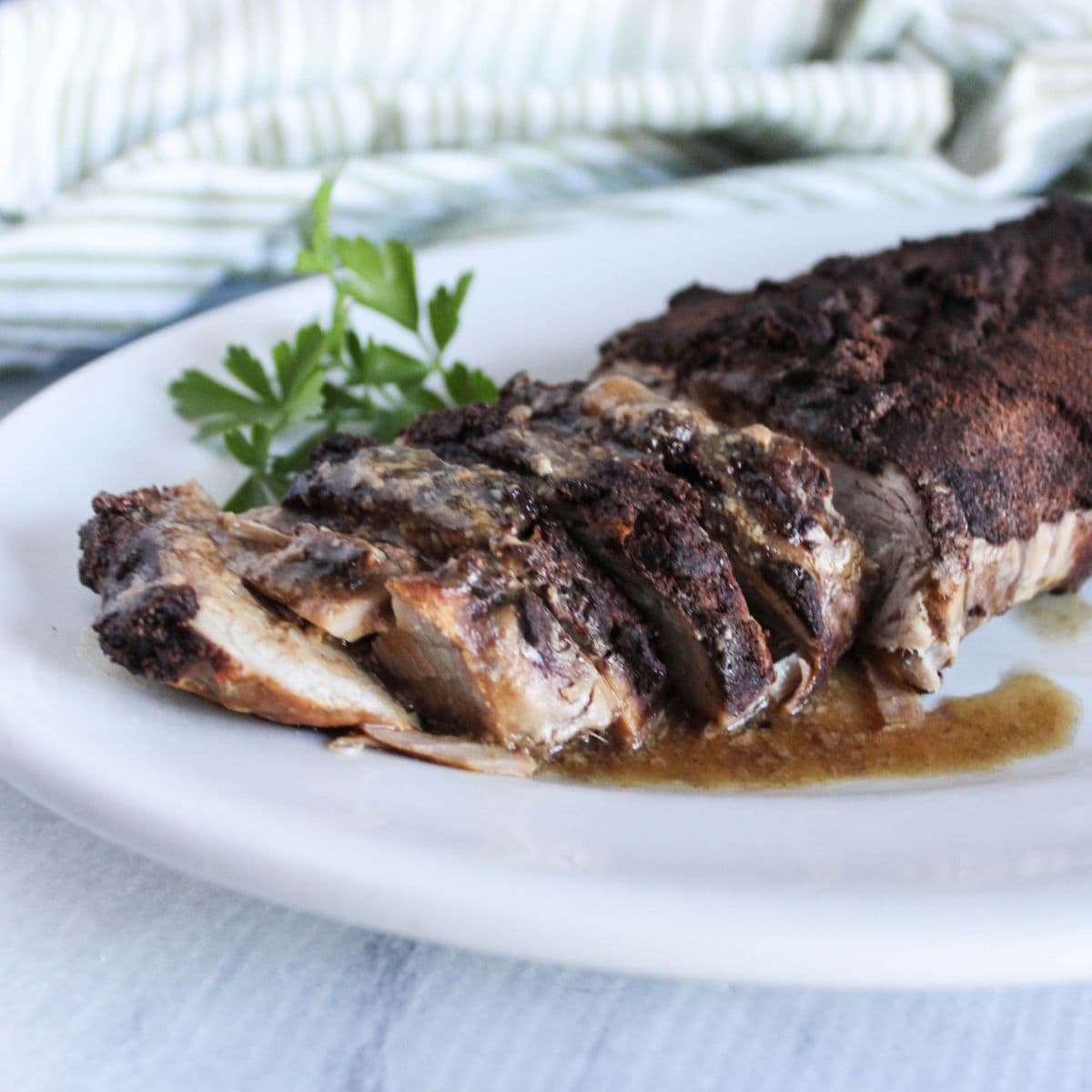 a picture of caribbean slow cooker pork tenderloin sliced on a white platter